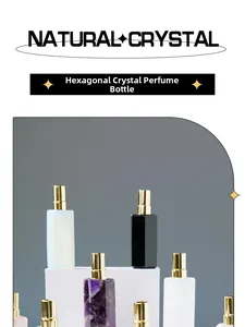 Detalle de frascos de perfume de cristal natural hexagonal con pulverizadores dorados