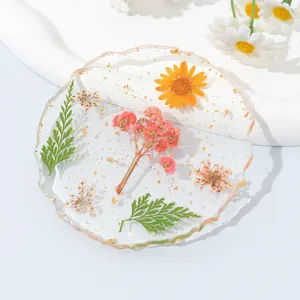 Vue détaillée d'un dessous de verre en résine avec de vraies fleurs et des flocons d'or