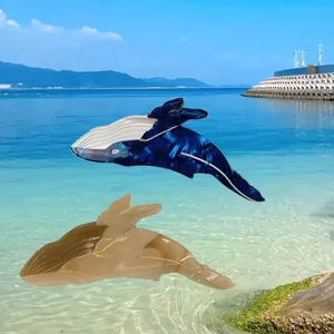 Dettaglio di due fermagli per capelli in acetato a forma di balena su uno sfondo di spiaggia.