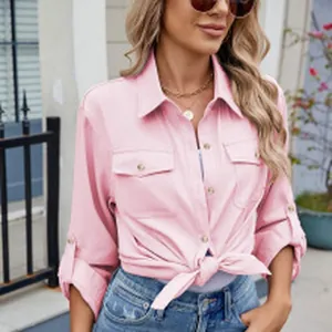 Gros plan d'une chemise rose à manches longues pour femme avec taille nouée et poches.