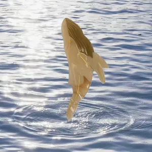 Primo piano di un fermaglio per capelli a forma di balena in acetato su sfondo oceanico
