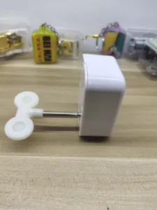 Gedetailleerd zijaanzicht van een wit mechanisch opwindbaar muziekdoosmechanisme.