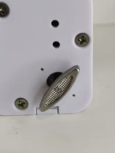 Detailopname van een wit opwindbaar muziekdoosmechanisme met een zilveren metalen opwindsleutel