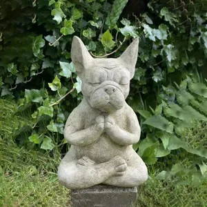 Detailed view of a Zen French Bulldog resin statue meditating in a green garden setting