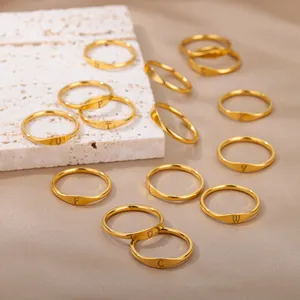 Close-up of gold minimalist rings with engraved alphabet letters A-Z