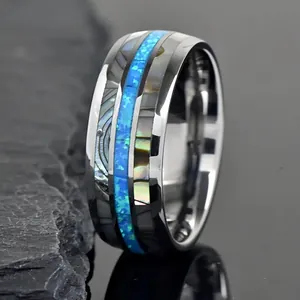 Detailed macro view of stainless steel ring with abalone shell and blue opal inlay
