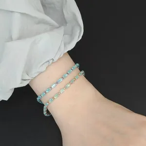 Vue détaillée de deux élégants bracelets en cristal bleu clair de forme carrée sur le poignet