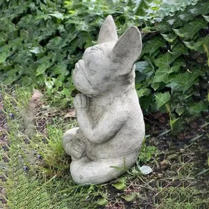 Side view of a meditating French Bulldog garden statue with realistic stone texture