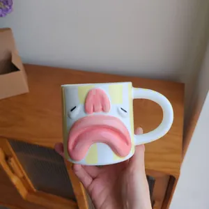 Close-up of funny ceramic blobfish mug with 3D pink features and yellow stripes