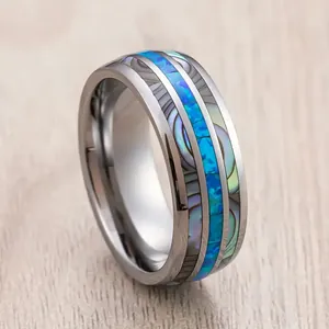 Close-up detail of stainless steel ring with abalone shell and blue stone texture