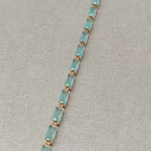 Gros plan d'un bracelet en pierres précieuses rectangulaires bleu clair plaqué or rose