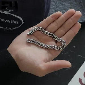 Close-up of a premium silver titanium steel Cuban link chain bracelet held in a hand