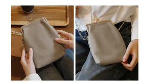 Detailed view of a grey pebbled leather crossbody phone bag with gold kiss-lock clasp