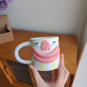 Detailed view of a creative ceramic coffee mug with a funny 3D big mouth and yellow stripes