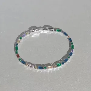 Gros plan d'un élégant bracelet en argent orné de cristaux multicolores éclatants taille baguette.