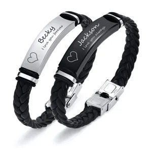 Macro view of engraved names and romantic phrases on couple's leather bracelets.