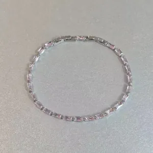 Bracelet tennis argenté élégant avec pierres roses taille baguette en cercle complet.