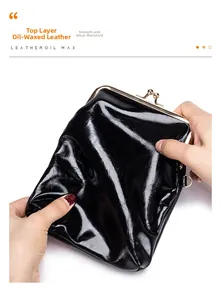 Detail showing the soft black oil wax leather texture on a vintage kiss-lock purse