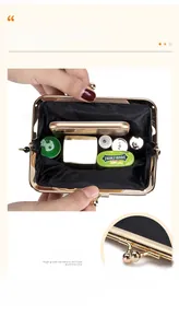 Interior capacity and clasp detail of a black leather vintage kiss-lock evening bag