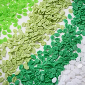 Vue détaillée de breloques de nail art en forme de feuilles vertes et blanches mixtes