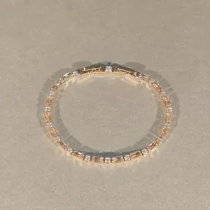 Détail d'un bracelet étincelant en or rose avec des cristaux géométriques ambrés