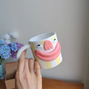Detailed view of quirky ceramic mug featuring 3D big lips and yellow striped pattern