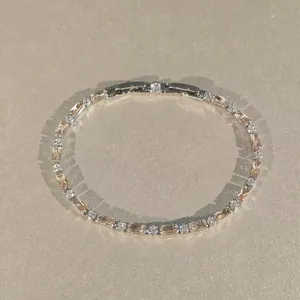 Détail macro de dessus d'un bracelet en argent avec des pierres baguette et rondes.