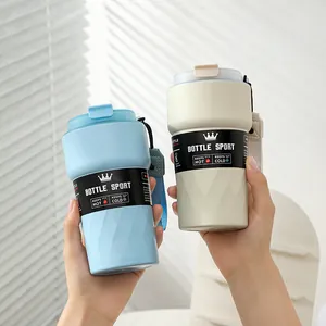 Detailed view of blue and cream 304 stainless steel insulated coffee mugs held by hands.