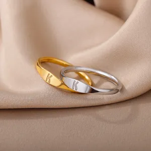 Close-up of polished gold and silver minimalist statement rings with engraved K initial