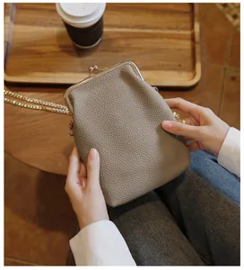 Detailed view of khaki leather phone bag with kiss-lock and gold chain strap