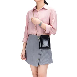 Elegant black genuine leather phone crossbody bag with gold chain strap on Asian model