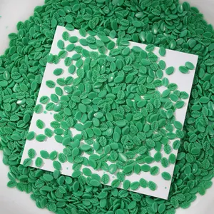 Vue détaillée de petites décorations d'ongles en forme de feuille verte pour manucure