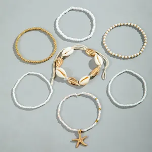 7-delige bohemien kralen enkelbandjes set met gouden zeester hanger en kaurischelpen