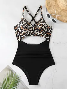 Gros plan d'un maillot de bain léopard une pièce avec découpe et design croisé.