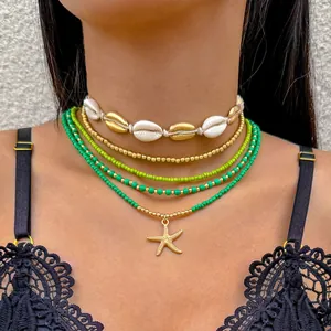 Detail van een bohemian kralen kettingset met zeester hanger en schelp choker op een model.