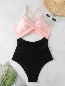 Détail d'un maillot de bain une pièce rose et noir avec découpe et design croisé