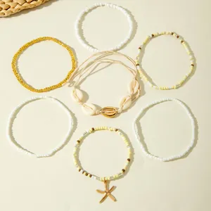 Detailweergave van bohemien kralen enkelbandjes set met zeester en schelp bedeltjes