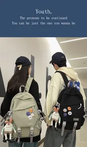 Detailed view of large capacity school backpacks in sage green and black with cute badges