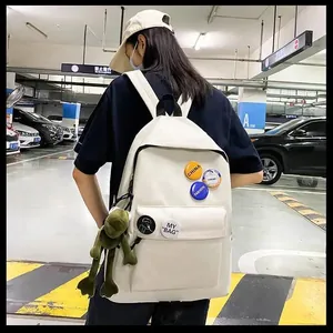 Sac à dos blanc minimaliste avec badges décoratifs et porte-clés pour étudiants