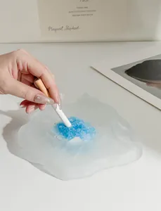 Close-up of frosted mountain-shaped glass ashtray with blue fireproof sand