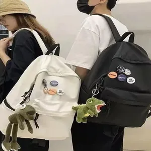 Vue détaillée de sacs à dos en toile simples noir et blanc avec de charmants pendentifs