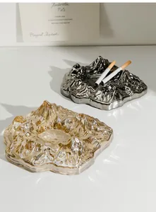 Macro detail showing the intricate textures of mountain-shaped glass ashtrays in clear and silver