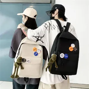 Deux étudiants portant des sacs à dos noir et blanc avec des badges et des breloques