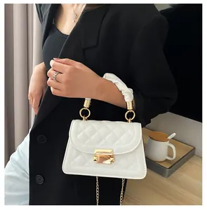 Elegant white quilted small square handbag with gold chain strap and ruffled handle.