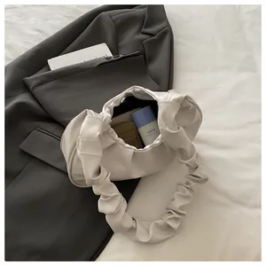 Dettaglio di una borsa a nuvola plissettata bianca con texture in morbida pelle e interno