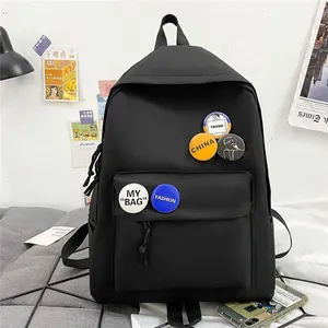 Sac à dos noir minimaliste grande capacité avec des badges tendance pour étudiants