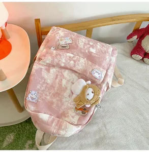 Macro view of the pink tie-dye printed backpack adorned with cute animal pins and charms