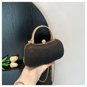 Elegant black glitter evening clutch bag with gold handle and chain strap for women.