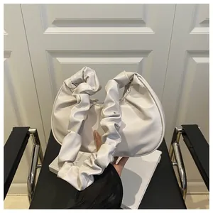 Primo piano della borsa nuvola a pieghe beige minimalista con manico arricciato