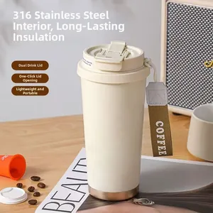 Cream 316 stainless steel coffee tumbler with strap and dual-drinking lid on a wooden table